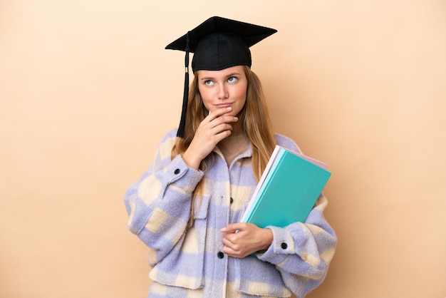 Mujer joven estudiante sobre un fondo aislado que tiene dudas mientras mira hacia arriba