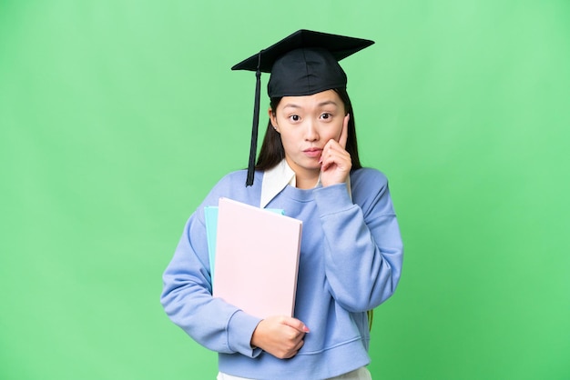 Mujer joven estudiante sobre fondo clave de croma aislado pensando en una idea