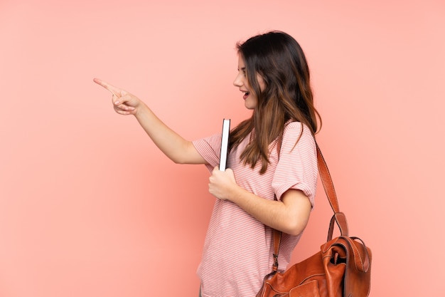 Mujer joven estudiante sobre pared aislada