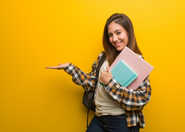 Mujer joven estudiante sosteniendo algo con las manos