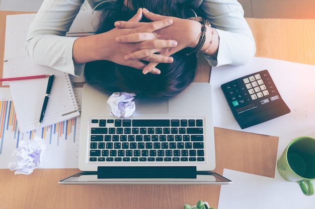 Mujer joven con exceso de trabajo y cansado durmiendo en el escritorio