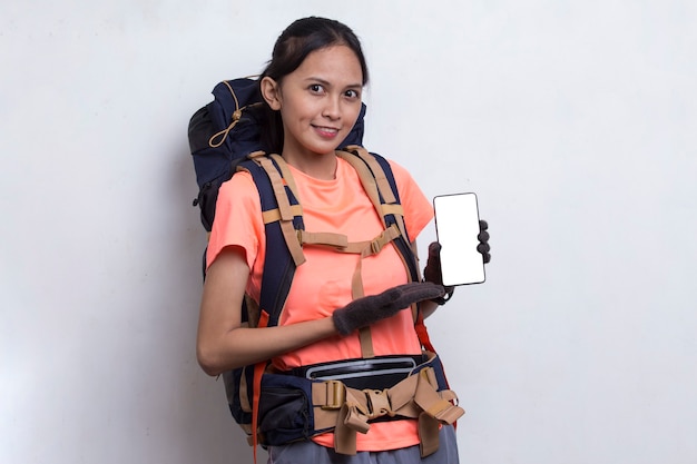 Mujer joven excursionista asiática mostrando teléfono móvil aislado sobre fondo blanco.