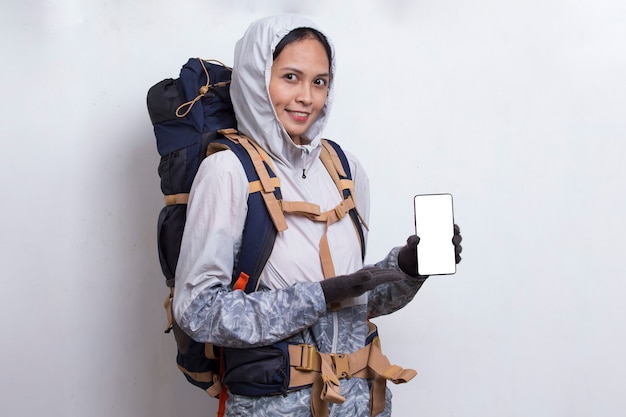 Mujer joven excursionista asiática mostrando teléfono móvil aislado sobre fondo blanco.