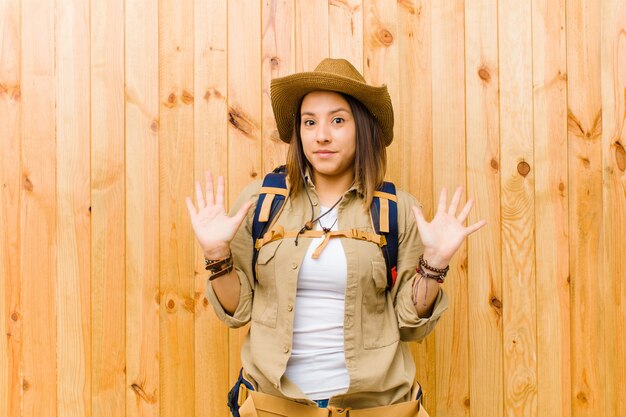 Mujer joven explorador latino contra el fondo de la pared de madera