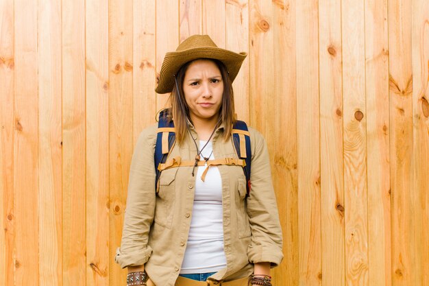 Mujer joven explorador latino contra el fondo de la pared de madera