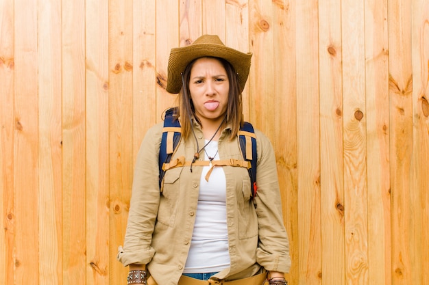 Foto mujer joven explorador latino contra madera