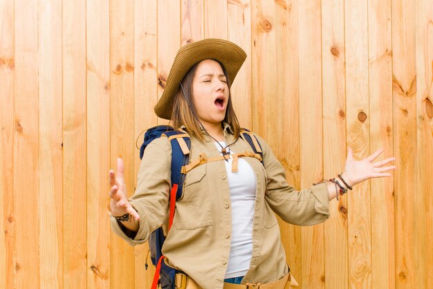 Mujer joven explorador latino contra madera