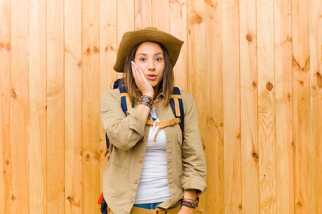 Mujer joven explorador latino contra la pared de madera