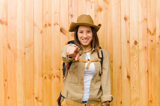 Mujer joven explorador latino contra la pared de madera