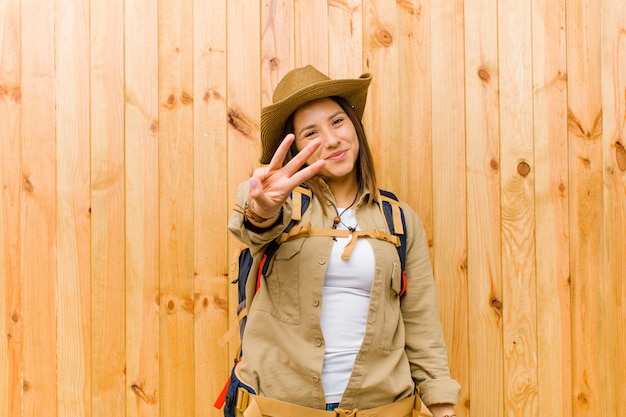 Foto mujer joven explorador latino contra la pared de madera