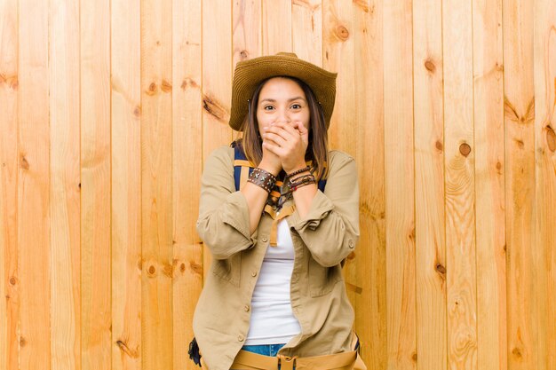 Mujer joven explorador latino contra la pared de madera