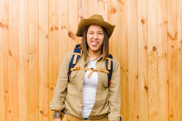 Mujer joven explorador latino contra la pared de madera