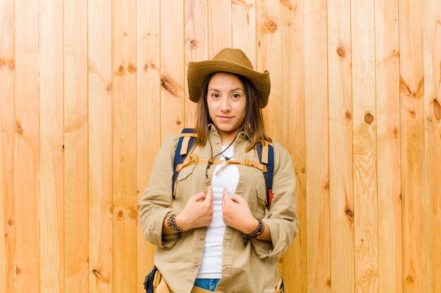 Mujer joven explorador latino contra la pared de madera