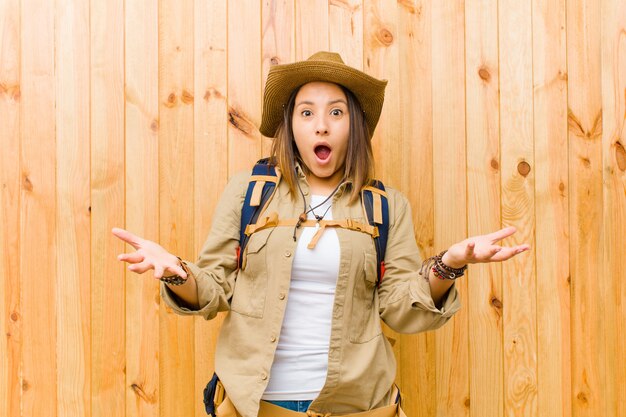 Mujer joven explorador latino contra la pared de madera