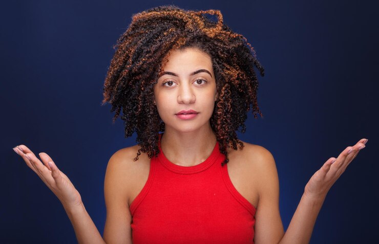 Foto mujer joven con una expresión sorprendida y disgustada sobre un fondo azul