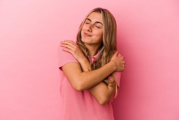 Mujer joven expresiva posando sobre fondo rosa