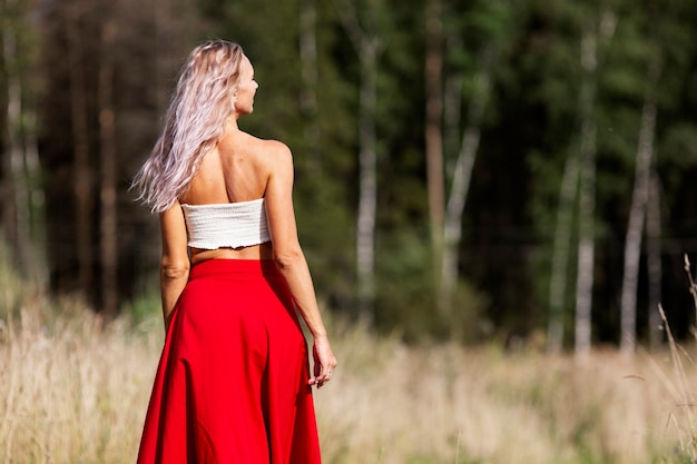 Mujer joven en una falda roja en el campo