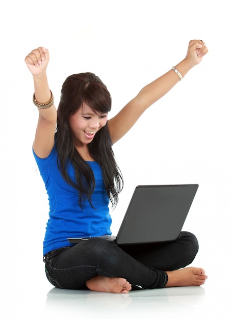 Mujer joven feliz y afortunada con laptop