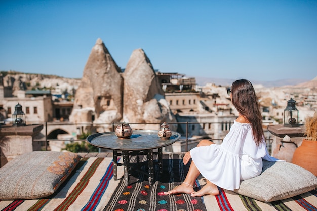 Mujer joven feliz durante el amanecer viendo globos de aire caliente en capadocia turquía