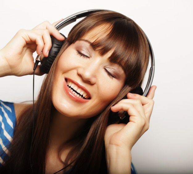 Mujer joven feliz con auriculares escuchando música