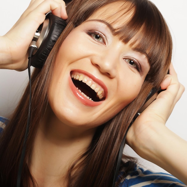 Mujer joven feliz con auriculares escuchando música