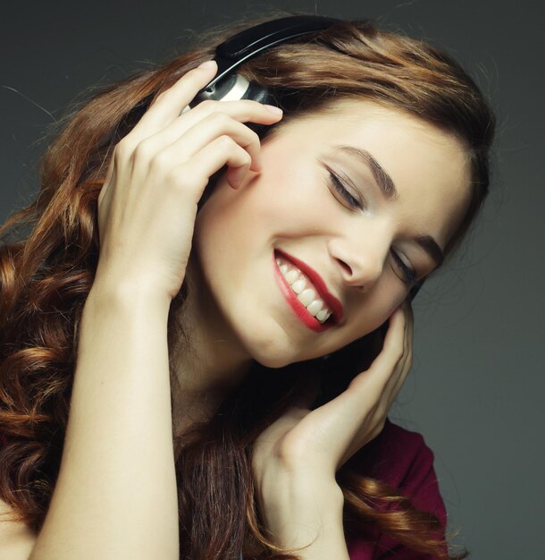 Mujer joven feliz con auriculares escuchando música