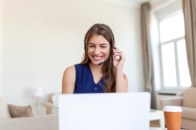 Mujer joven feliz en auriculares hablando mirando la computadora portátil haciendo notas mujer de negocios hablando por videoconferencia Conferencia por cámara web formación en línea concepto de ecoaching