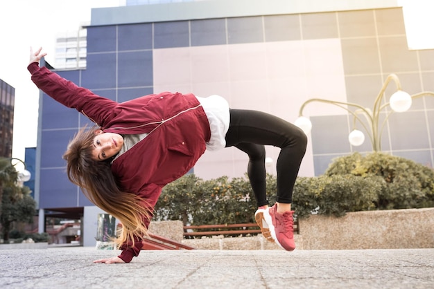 Mujer joven feliz bailando en la calle