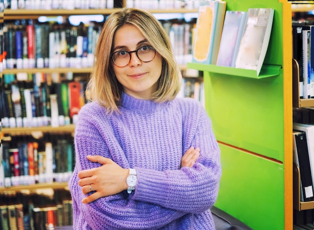 Mujer joven feliz en una biblioteca