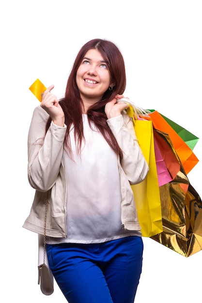 Mujer joven feliz con bolsas de compras y tarjeta de crédito