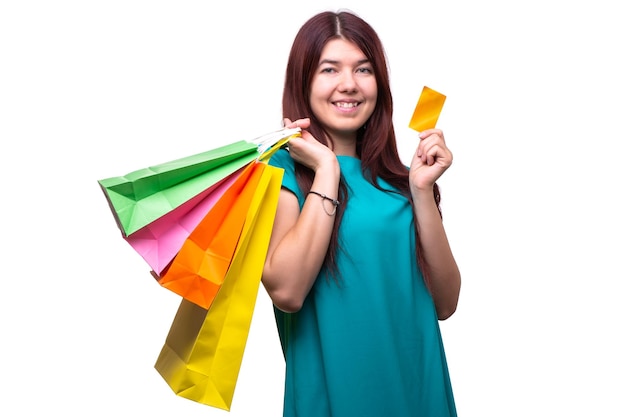 Mujer joven feliz con bolsas de compras y tarjeta de crédito