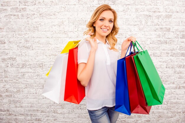 Mujer joven feliz con bolsas de papel de colores