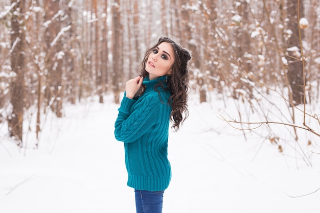 Mujer joven feliz caminando en invierno.