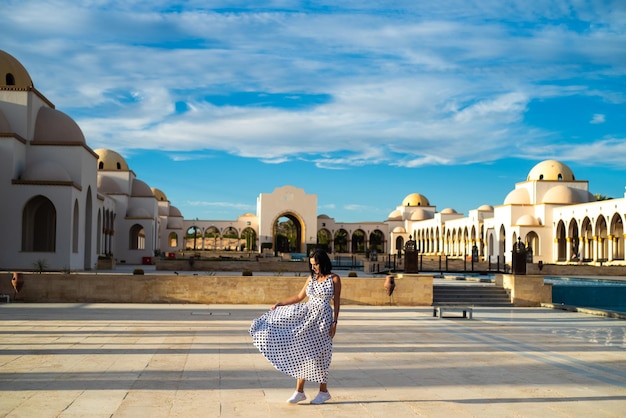 Mujer joven feliz caminando en el territorio del hotel Vacaciones de verano en Egipto Aspecto elegante y de moda