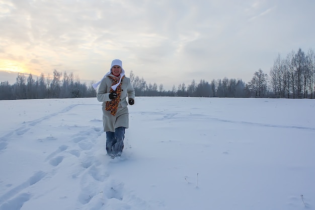 Mujer joven feliz en campo cubierto de nieve