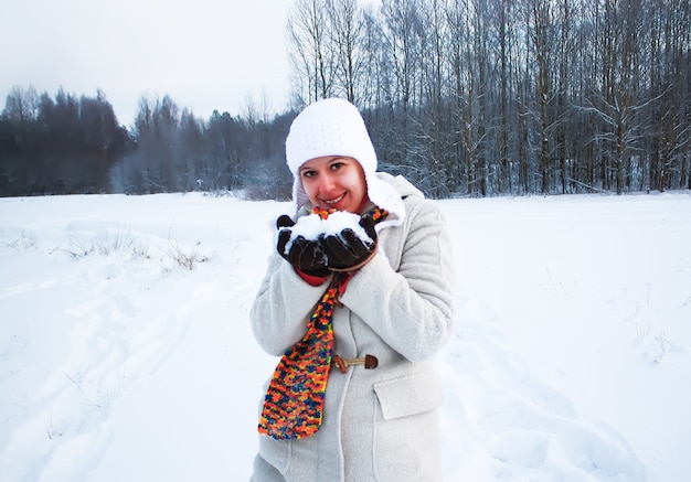 Mujer joven feliz en campo cubierto de nieve