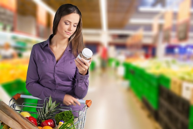 Foto mujer joven feliz con carrito de compras