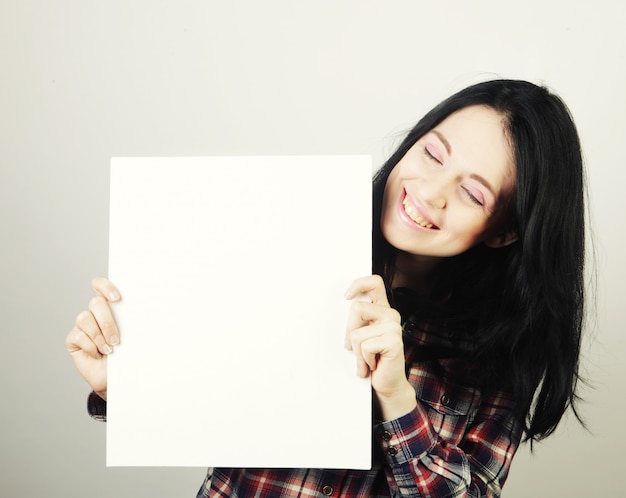 Mujer joven feliz con cartel en blanco