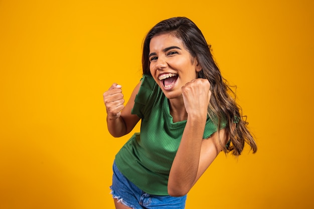 Mujer joven feliz celebrando con el concepto de logro. sí