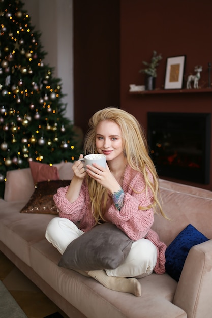 Mujer joven feliz celebrando la Navidad en casa