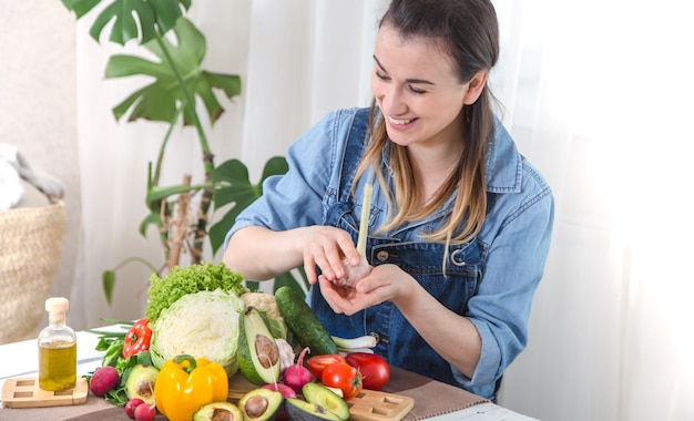 Mujer joven y feliz comiendo ensalada en la mesa