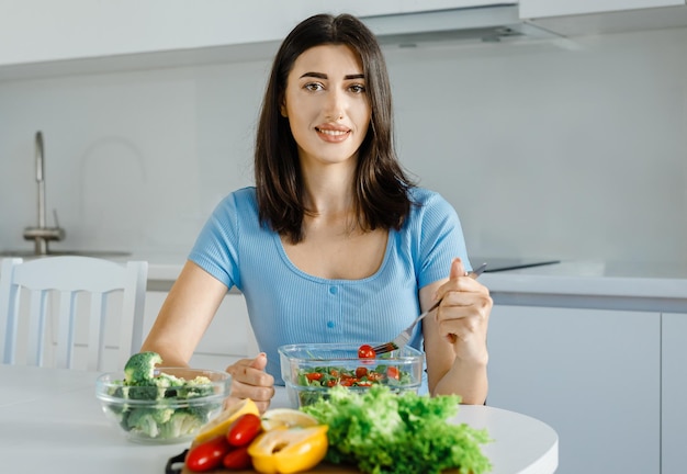 Mujer joven feliz comiendo ensalada saludable Dietista femenina sonriente