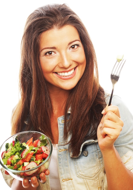 Mujer joven feliz comiendo ensalada