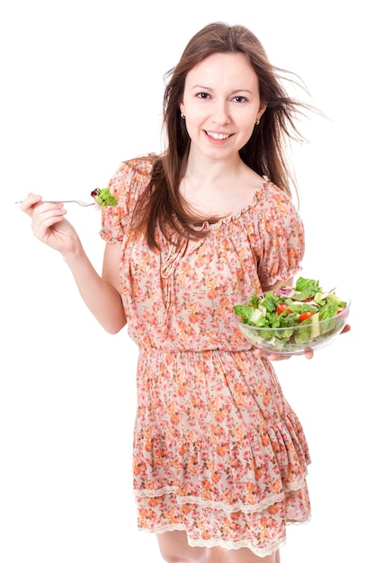 Mujer joven feliz comiendo ensalada.