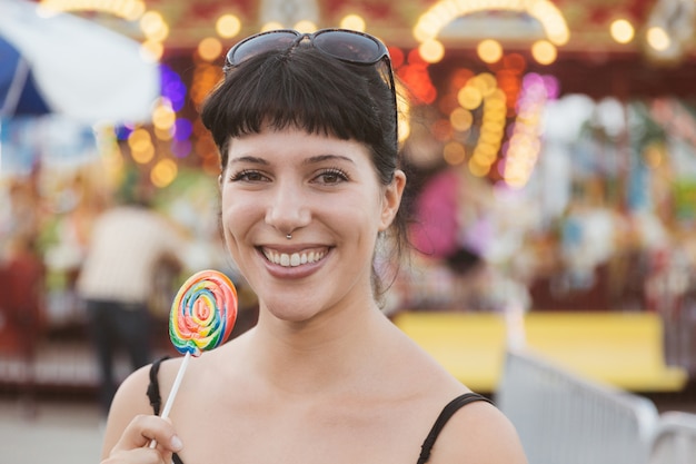 Mujer joven feliz comiendo Lollipop