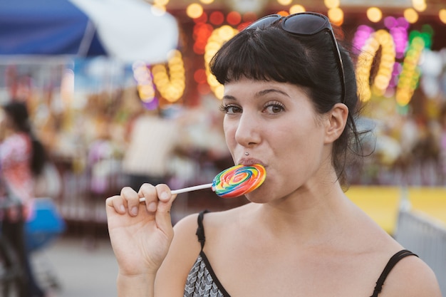 Mujer joven feliz comiendo Lollipop