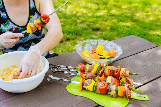 Mujer joven feliz comiendo shish kebab de pollo