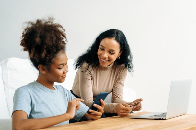 Mujer joven feliz compra producto comprando en línea en casa mientras ordena artículos de Internet con tarjeta de crédito sistema de pago en línea protegido por seguridad cibernética crucial de la plataforma de tienda en línea