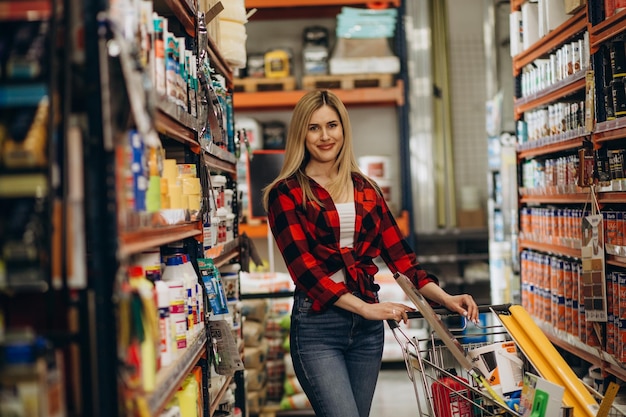 Mujer joven feliz de compras en la ferretería