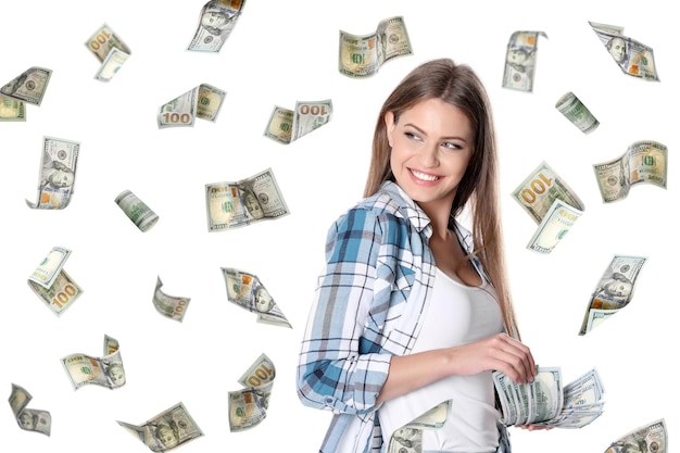 Mujer joven feliz con dinero y dólares americanos cayendo sobre fondo blanco